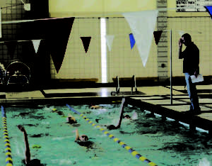 VISION OF EXCELLENCE: Head Coach Chris Plumb looks on as the women’s swim team does the backstroke during practice. The Hounds’ next varsity meet is Sectional Preliminaries on Feb. 5 at Noblesville. KATE GRUMME / PHOTO