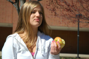 SLIMMING DOWN: Junior Megan Bournique eats an apple. Bournique works out at least four times a week and maintains a healthy diet not only to get in shape for spring break, but also to make herself feel confident. ARJUNA CAPULONG / PHOTO