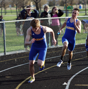 IN SYNC: Senior Dean Weaver hands off to teammate and sophomore Justin Batten in the 400-meter relay. The 400-meter relay team works extensively on handoffs during practice in order to run the fastest time possible during meets. NICK JOHNSON / PHOTO