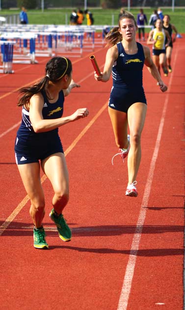 HAND TO HAND: Junior Ellie Taff hands the baton to junior Katie Doron during the women’s 3,200-meter relay. The women’s 3,200-meter relay team is one of the favorites to win the State meet this season, and Taff and Doron both ran on the team that finished third at the State meet last season. NICK JOHNSON / PHOTO