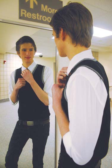 MIRROR, MIRROR: Junior Reid Watson fixes his tie in a mirror. Although he said he started dressing up when required by his job, he said he does so now because he enjoys looking more professional.