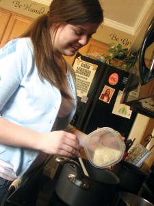 FAMILY COOKING: Senior Taylor Knowlton prepares a meal for her family of eight. Though the Knowltons regularly sit down and eat together, the habit is becoming increasingly rare among many American households. POOJA MATHUR / PHOTO